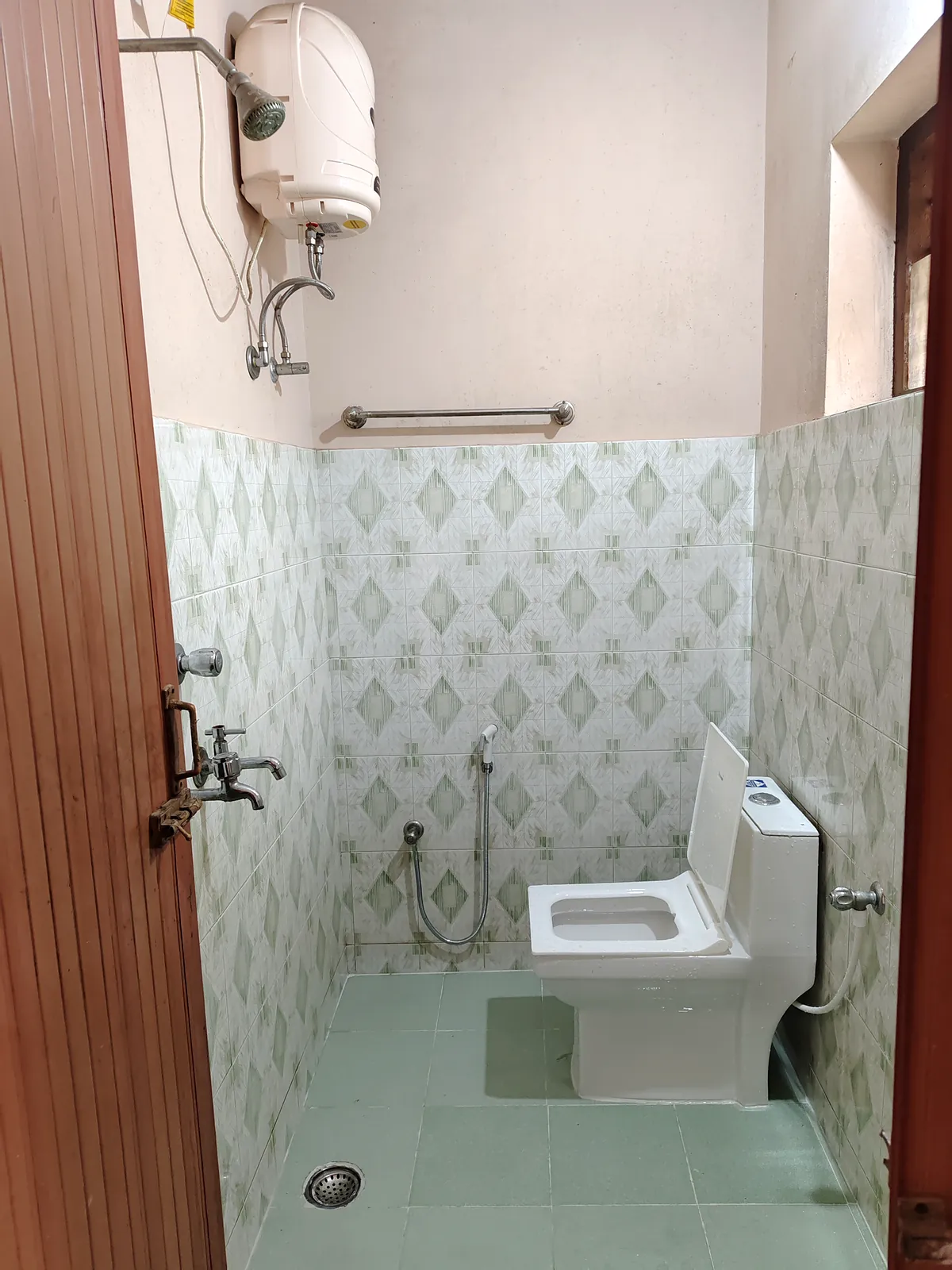 Tiled attached bathroom with a water heater and shower