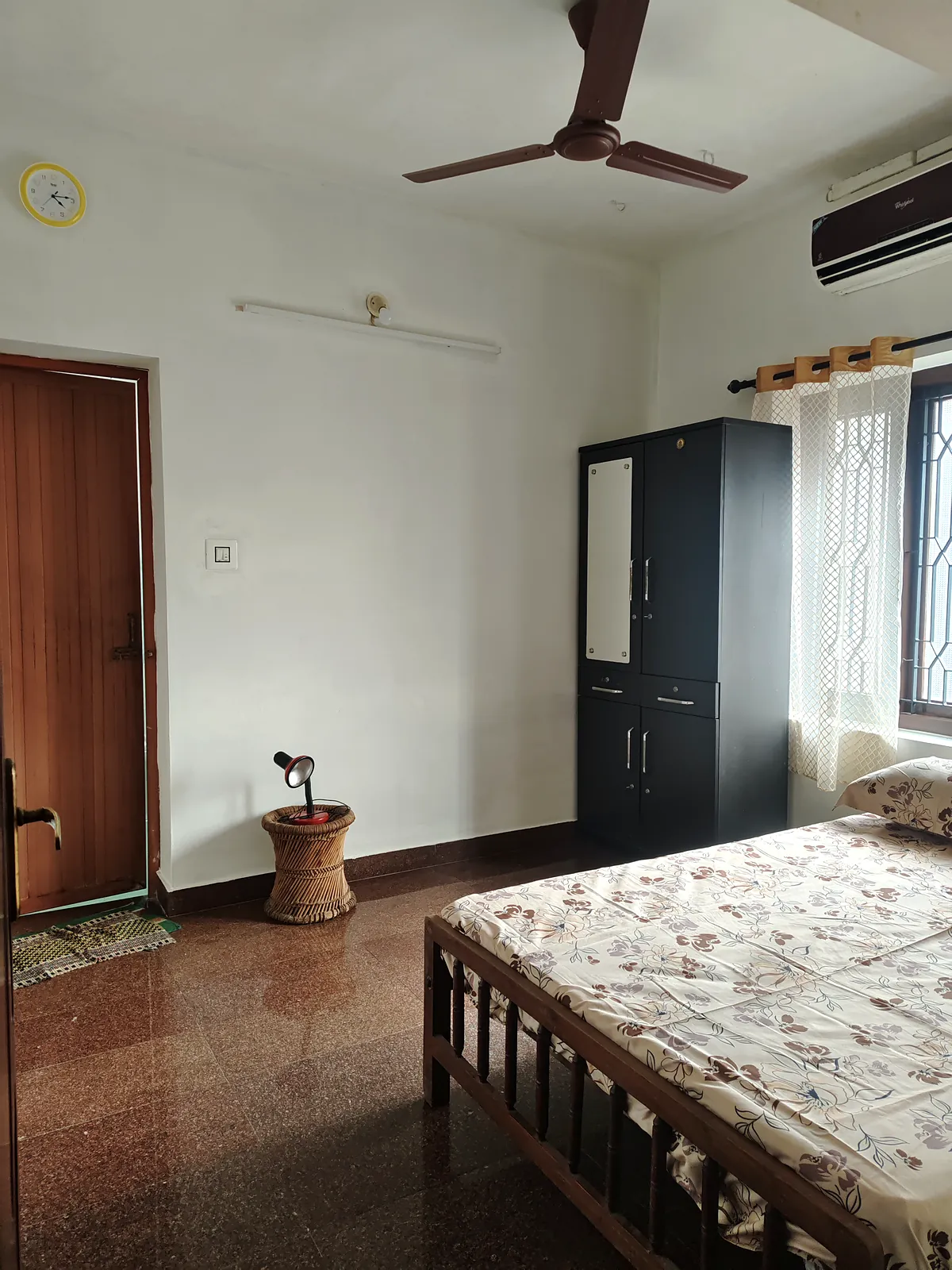 Air-conditioned ensuite bedroom on the ground floor at Gowreesam Homestay, with a wardrobe and reading lamp