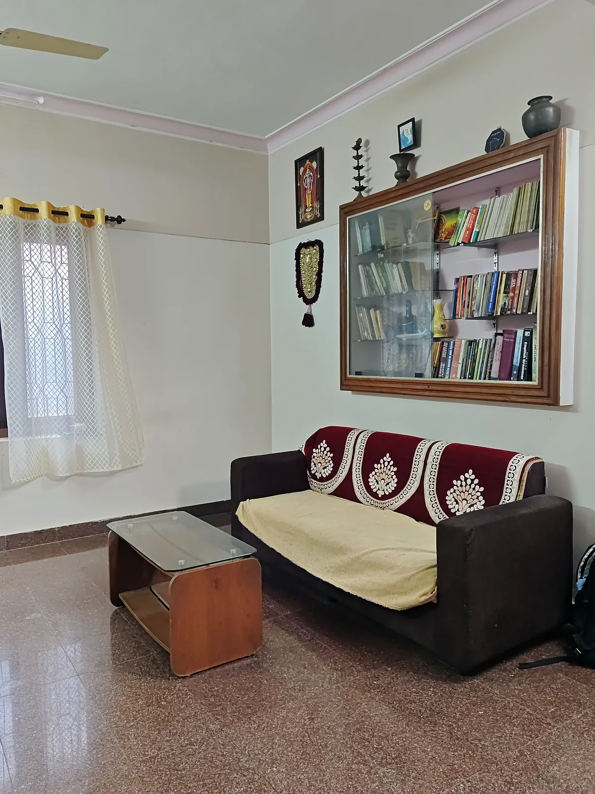Sitting room with a sofa and a glass-fronted bookcase